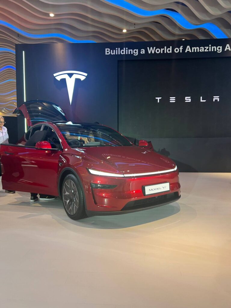 Tesla Model Y displayed at Pune expo April 2026 India launch event. For anyone using an EV charge time calculator 2026 how long to full for your model in US and Europe, the Model Y charges 20-80 percent in approximately 22 minutes on a V3 supercharger — a key metric for Indian buyers considering this electric SUV.